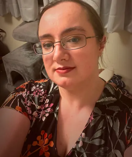 Portrait of Kella Hanna-Wayne wearing glasses and a floral top.